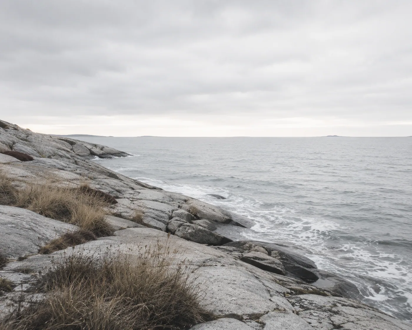 Felsige Küste am Nordmeer mit Wellen und grauem Himmel – Motiv für Meer & Küste als Fototapete